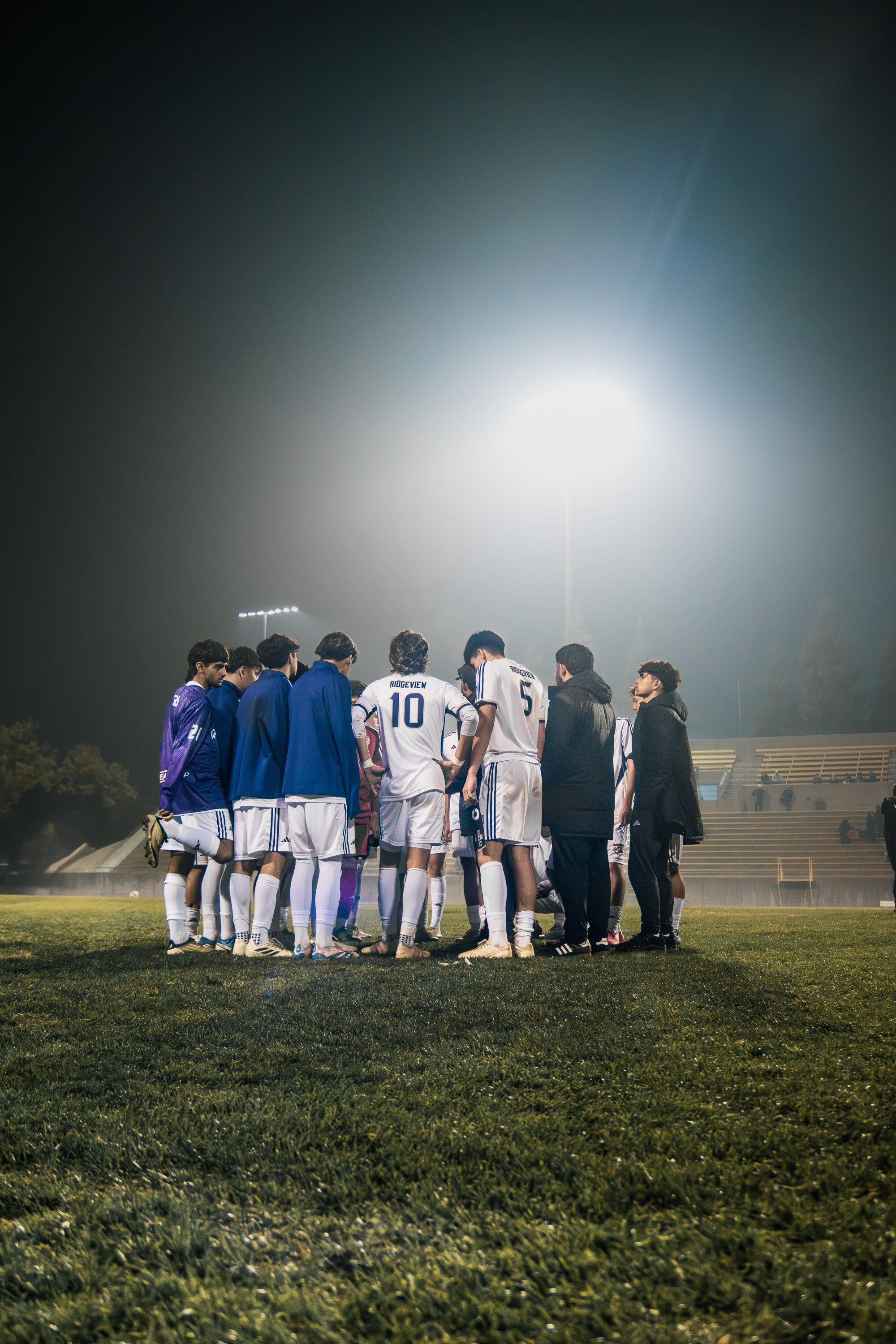 Ridgeview players gathered in a huddle beneath the stadium lights